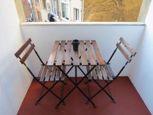 a wooden table and two chairs sitting next to a window at Hostal Petit Príncep in Barcelona