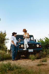 a man and a woman sitting on the back of a truck at Indomito Resort & Hotel Boutique in Valle de Guadalupe