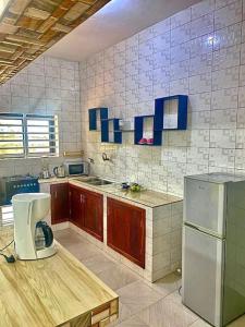 cocina con nevera congelador y encimera en Appartement climatisé et cozy., en Abomey-Calavi