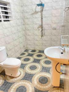 y baño con ducha, aseo y lavamanos. en Appartement climatisé et cozy., en Abomey-Calavi