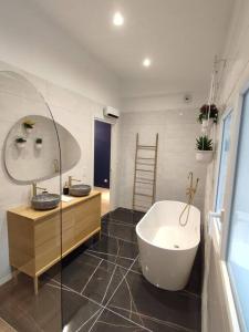 a bathroom with two sinks and a bath tub at Appartement Le Secret, Proche Sanctuaires in Lourdes