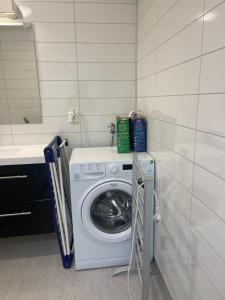 a laundry room with a washing machine and a sink at Lovely apartment with parking in the heart of city in Lillehammer