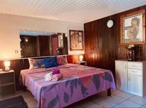 1 dormitorio con 1 cama grande con manta morada en Fare ManuVai, en Haapu