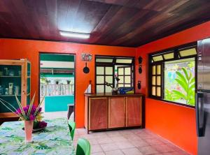 cocina con paredes de color naranja y mesa en una habitación en Fare ManuVai, en Haapu
