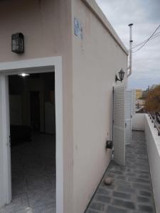 Un edificio blanco con una puerta al costado. en Monoambiente céntrico, en San Luis