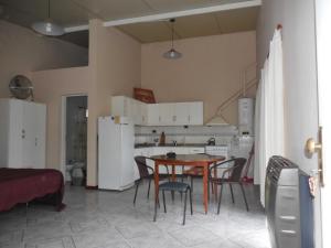 Una cocina y un comedor con mesa y sillas. en Monoambiente céntrico, en San Luis 2 fotos más