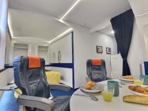 ein Zimmer mit Stühlen und einem Tisch mit Essen darauf in der Unterkunft Insolite - Jet Privé - Expérience Cinéma et coc00ning - Moontown in Lunéville