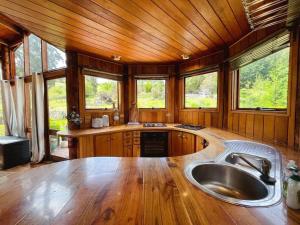 a kitchen with a large sink and some windows at The 'Nook' - Cabin in the Tassie Wilderness! in Ridgeway