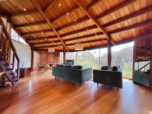 a large living room with couches and a wooden ceiling at The 'Nook' - Cabin in the Tassie Wilderness! in Ridgeway