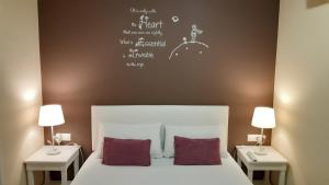 バルセロナにあるホステル プチ プリンセップのベッドルーム1室(ベッド1台、テーブル2台、ランプ2つ付)