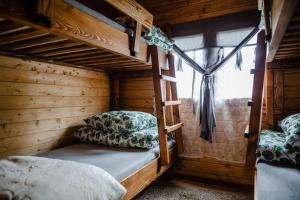 sypialnia z 2 łóżkami piętrowymi i oknem w obiekcie Domki na Górniej Łące - Domek Słowik w mieście Łazany