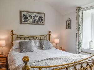 a bedroom with a bed with two pillows on it at Ty Dyfnant Cottage in Penmachno