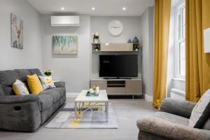a living room with a couch and a tv at Modern 3 and 2 bedroom flat in central london with full AC in London