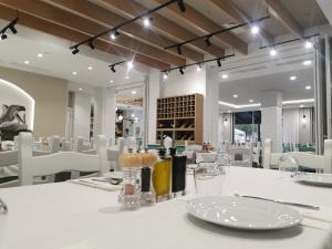 comedor con mesa blanca y sillas blancas en Hotel Pelikan, en Divjakë