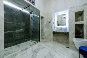 a bathroom with a glass shower and a sink at CASA DIVINUS SUITES in Athens