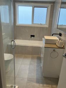 La salle de bains est pourvue d'une baignoire, d'un lavabo et de toilettes. dans l'établissement Self contained guest suite, à Oatlands