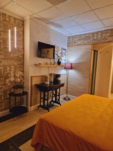 1 dormitorio con 1 cama y escritorio con TV en São Pedro Suite Faro, en Faro