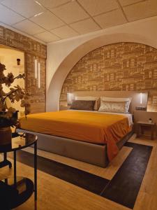 1 dormitorio con 1 cama grande y pared de ladrillo en São Pedro Suite Faro, en Faro