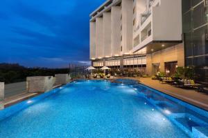 a swimming pool in front of a building at night at Four Points By Sheraton Visakhapatnam in Visakhapatnam