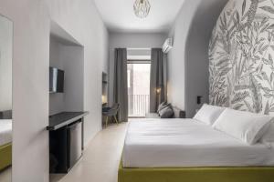 a hotel room with a bed and a tv at La Regina del Duomo Catania Centro in Catania