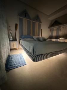 una camera da letto con un letto e un tappeto sul pavimento di beach house a Chioggia