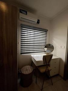 Habitación con escritorio y ventana con ventilador. en Light, modern apartment in Ikoyi, en Lagos