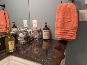 a bathroom counter with bottles of alcohol and a towel at Mountain House of Wonder in Qualicum Beach