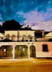 un gran edificio blanco con puertas y balcón en Ámbar Hostel San Gil en San Gil