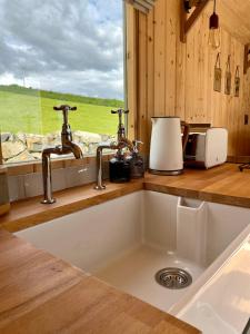a kitchen counter with a sink and a window at The Stone Wall Hideaway in Portglenone