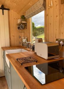 a kitchen with a sink and a microwave on a counter at The Stone Wall Hideaway in Portglenone