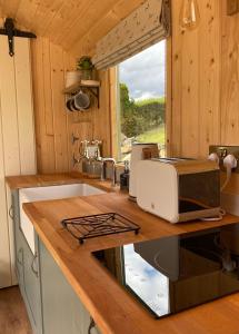 a kitchen with a sink and a microwave on a counter at The Stone Wall Hideaway in Portglenone +30 photos