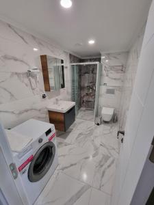 une salle de bains blanche pourvue d'un lave-linge. dans l'établissement Royal Homes 405, à Antalya
