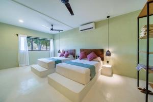 - 2 lits dans une chambre aux murs verts dans l'établissement Hotel Bindani’, à Santa Cruz Huatulco