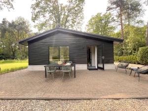 a black shed with a table and chairs at Quercus in Valkenswaard