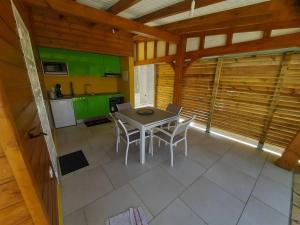 uma cozinha com mesa e cadeiras num quarto em bungalow hibis.kiss971 em Baie-Mahault