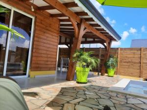 un patio con 2 plantas en grandes jarrones verdes en bungalow hibis.kiss971 en Baie-Mahault