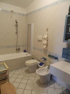 a bathroom with a toilet and a tub and a sink at Appartamente moderno e accessoriato. in Pula
