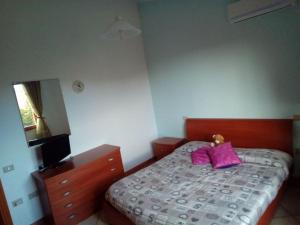 una camera da letto con un letto con cuscini rosa e un comò di Appartamente moderno e accessoriato. a Pula