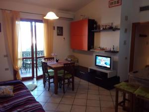a living room with a dining room table and a television at Appartamente moderno e accessoriato. in Pula