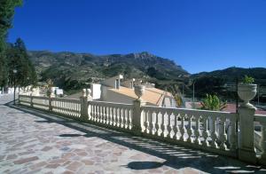 una recinzione di fronte a una casa con montagne sullo sfondo di La LLar de Julia a Tibi
