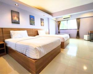 a bedroom with two beds and a window at AIRBEST Gemtree Lampang Hotel in Lampang