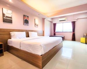 a bedroom with a large bed in a room at AIRBEST Gemtree Lampang Hotel in Lampang