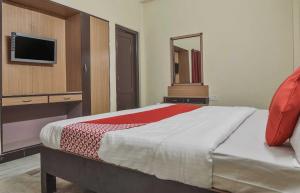 a bedroom with a bed with a mirror and a tv at Hotel Kathir Palace in Madurai