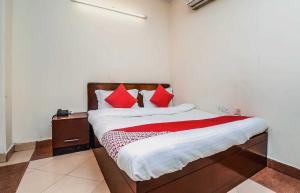 a bedroom with a bed with red pillows on it at Hotel Kathir Palace in Madurai