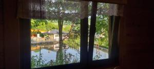 una finestra con vista sulla piscina di Domek Nad Stawem I a Limanowa