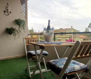 - une table et des chaises sur un balcon avec une bouteille de vin dans l'établissement Matilde casa vacanze, à Santa Luria