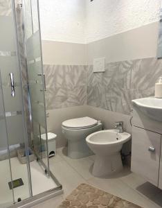 La salle de bains est pourvue de toilettes, d'un lavabo et d'une douche. dans l'établissement Matilde casa vacanze, à Santa Luria