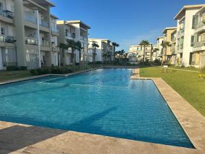 a swimming pool in front of some apartment buildings at Casa bay sidi rahal in Sidi Rahal
