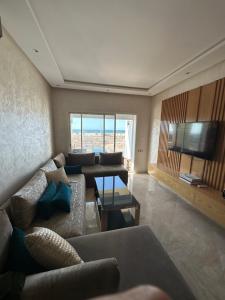 a living room with a couch and a television at Casa bay sidi rahal in Sidi Rahal