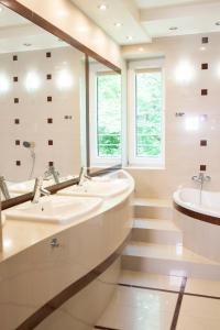 La salle de bains est pourvue de 3 lavabos, d'une baignoire et d'un escalier. dans l'établissement Ohana Space w Juracie, à Jurata